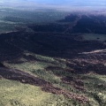 Burned area shows black with green vegetation surrounding.