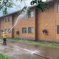 Logistics section chief Dane Smigleski sprays down the Chena Hot Springs Resort hotel with water to protect it from the advancing Munson Creek Fire on Monday evening, July 5, 2021.